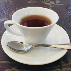 白いカップに注がれたアッサムティーと銀のスプーンが乗ったソーサー
